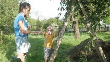 <strong>一个</strong>可爱的男孩和他的母亲在<strong>樱桃</strong>树附近。 <strong>一个</strong>女人拿出石头给她儿子浆果。